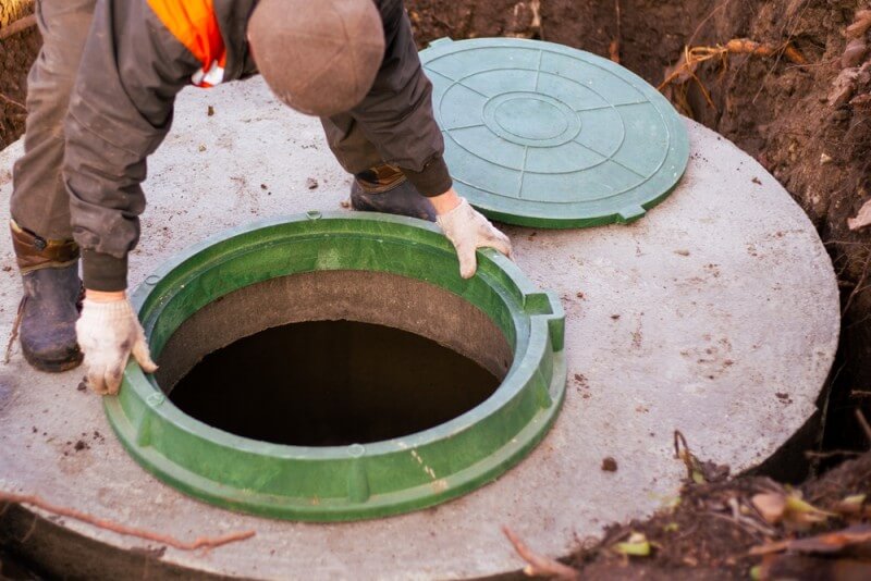 barbat care verifica constructia unei fose septice pentru o casa in zona rurala